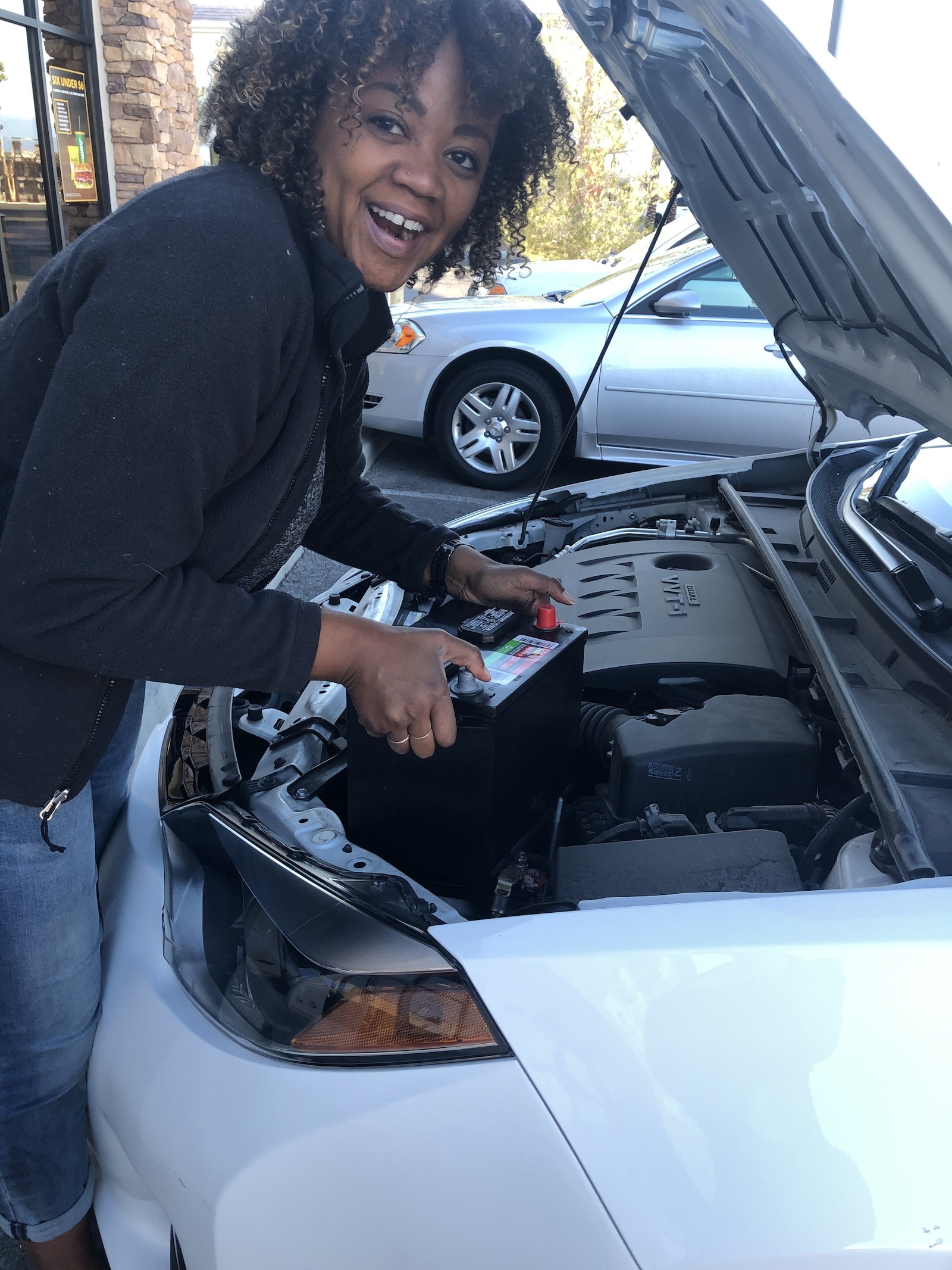 Changing a car battery in a parking lot